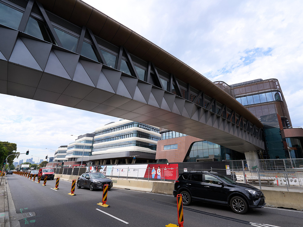 Modern grey industrial bridge runs over a busy road