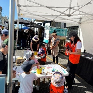 Curious children and their parents mill around a table of curiousities