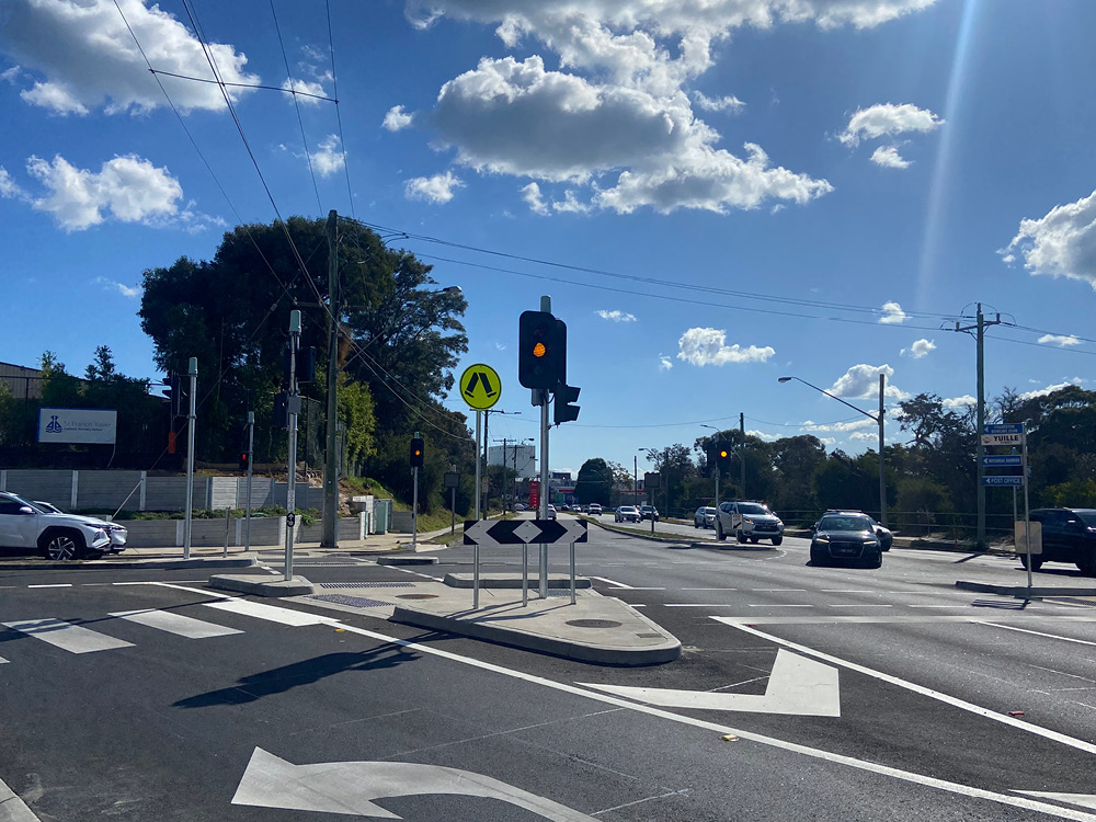 A green traffic light on and island in the middle of an intersection