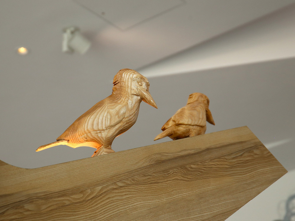 handcrafted wooden birds on a beam
