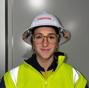 Close up of a woman wearing glasses and a hard hat