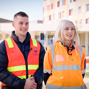 two people in hi vis smile at camera