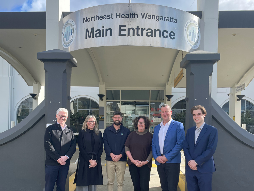 Six people standing under the Northeast Health Wangaratta Main Entrance sign.