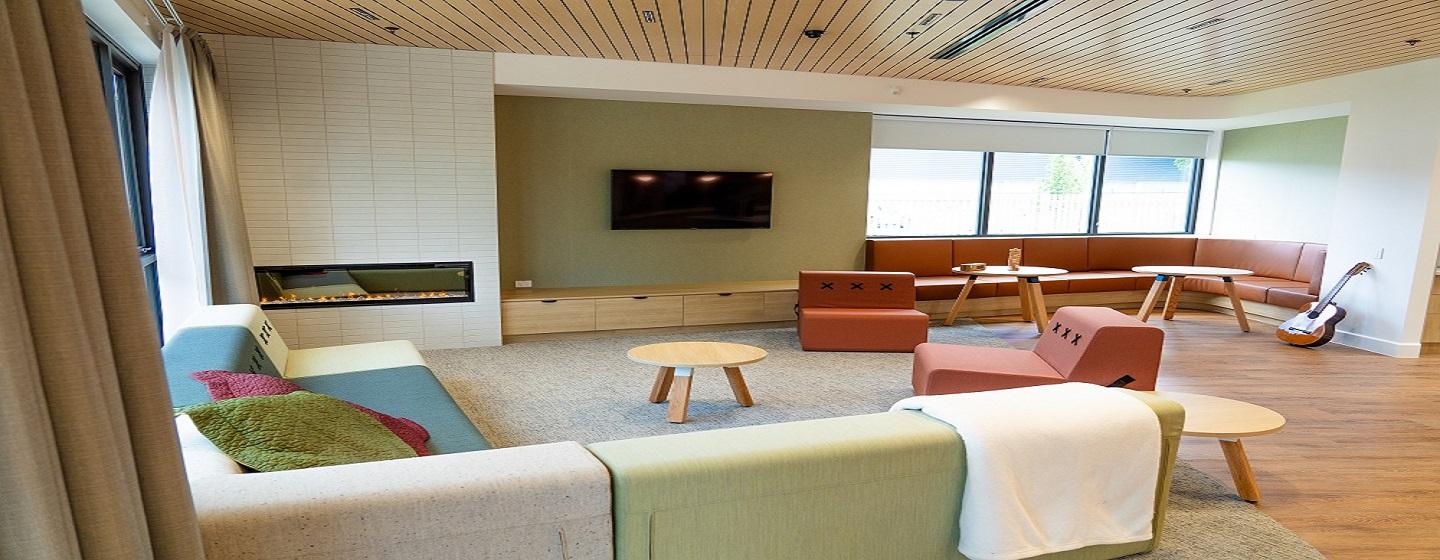 A communal area with coloured couches and leadlight windows