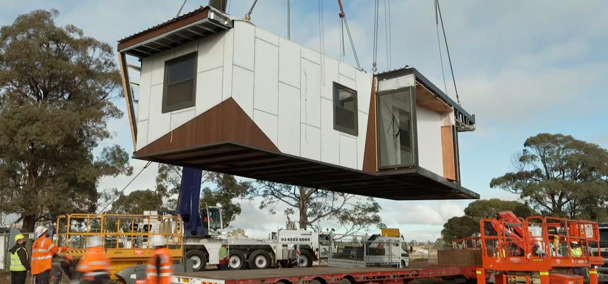 A section of the Corio rehabilitation facility being lifted in the air by a crane.
