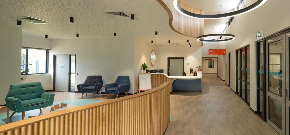 A modern and calming interior with wood tones and teal chairs