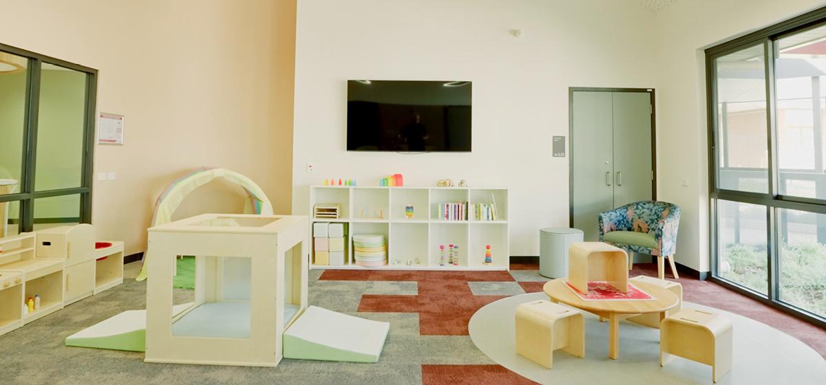 A welcoming looking room with toys and colourful rugs