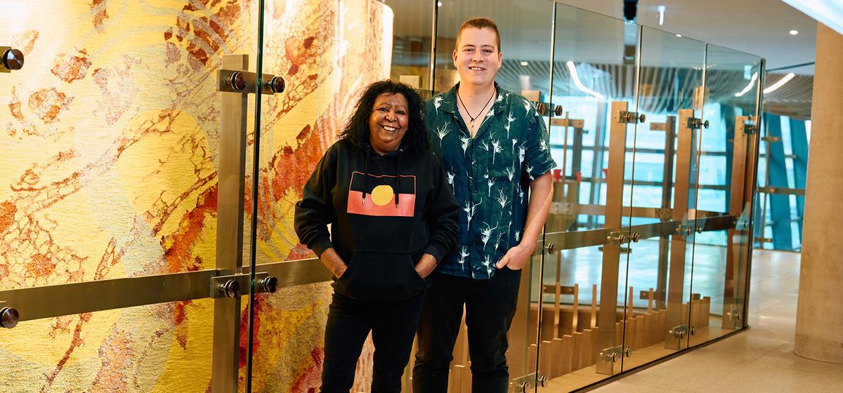A woman and man stand proudly in a building foyer