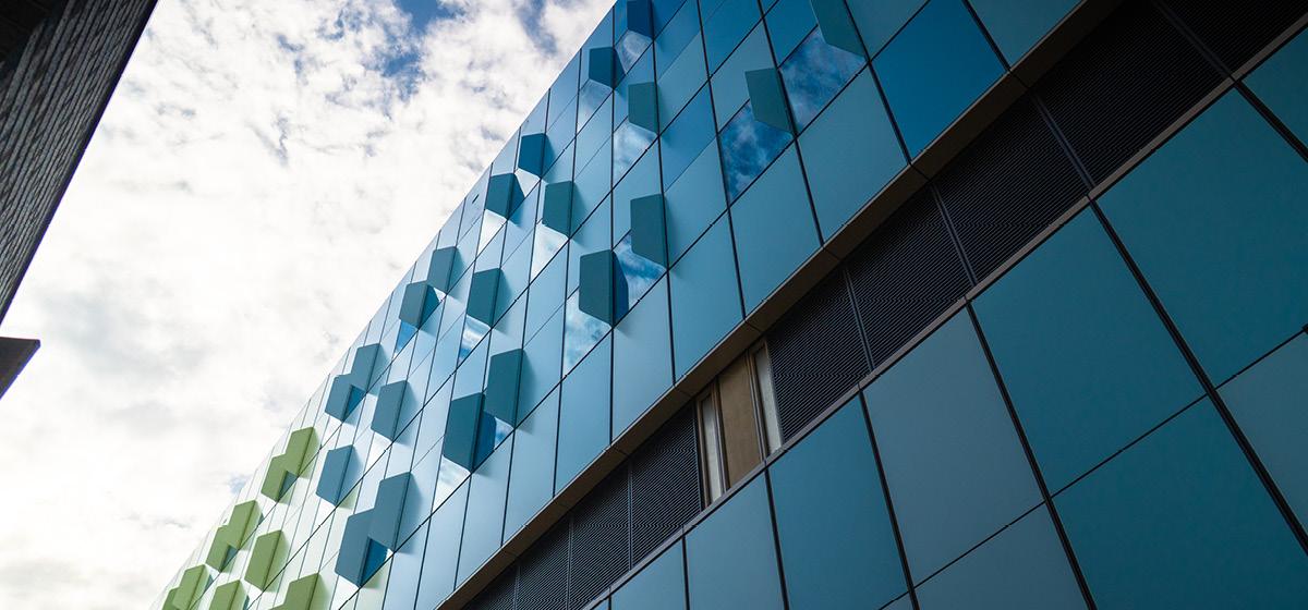 Close-up of the Barwon Women's and Children's building exterior, showing blue and green glass panels against the sky.