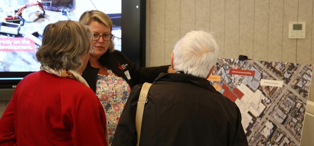 People viewing site plans and discussing the hospital redevelopment at a community consultation session