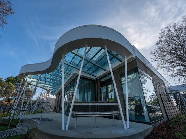 The outside of the Echuca Cancer and Wellness Centre. It has white poles and a curved roof with glass.