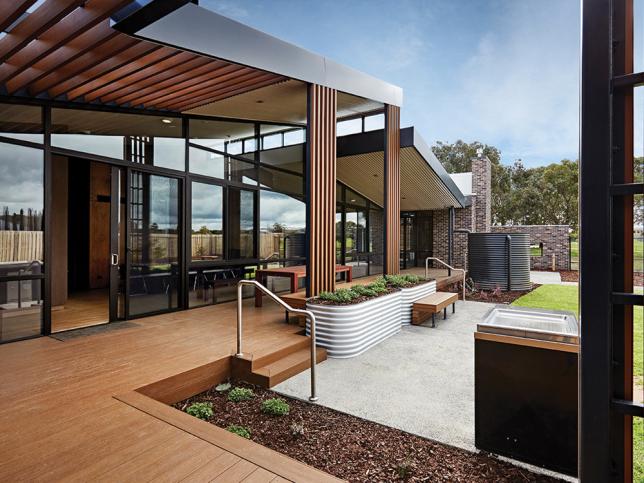 Outdoor wooden decking area with a barbecue and corrugated plant beds