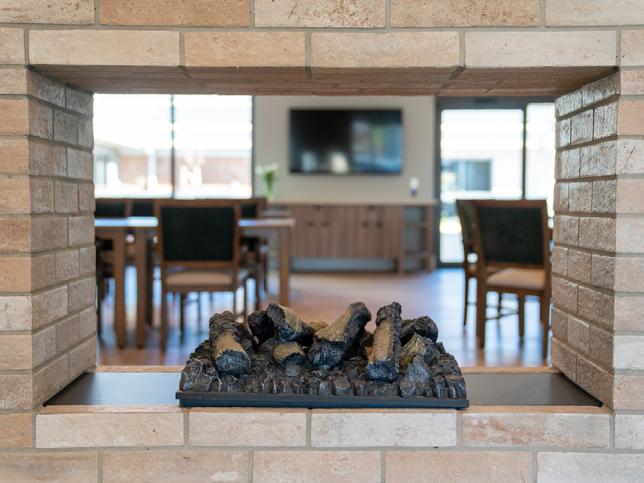 A decorative fireplace with a dining room visible behind