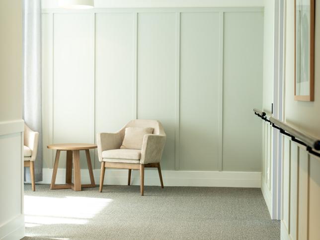 An open room with white walls, padded seats and a small table