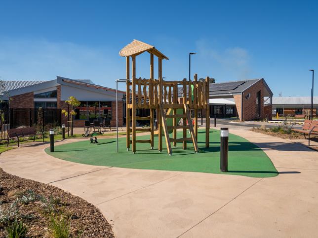 An outdoor play area with a small timber playground