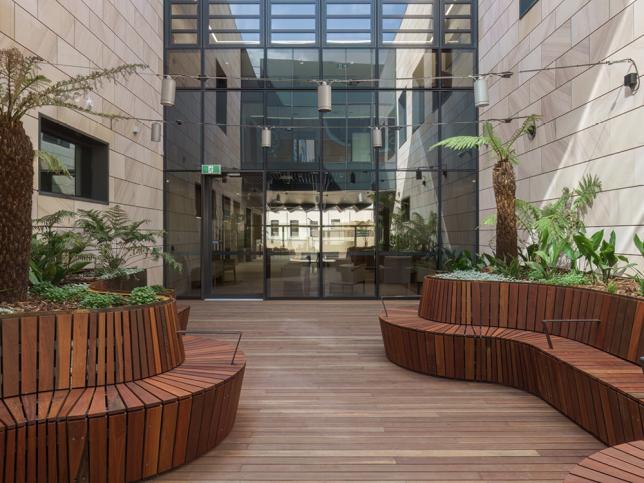 Courtyard area with timber floors and seating, and stone walls