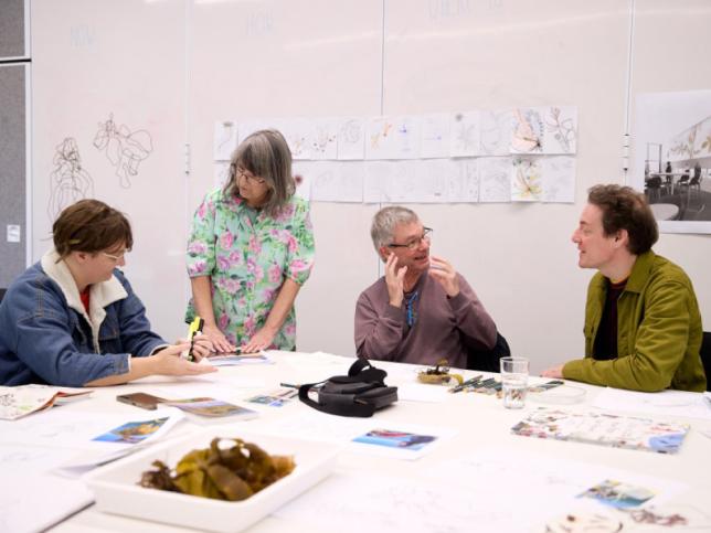 Four people sitting at a table, talking and smiling