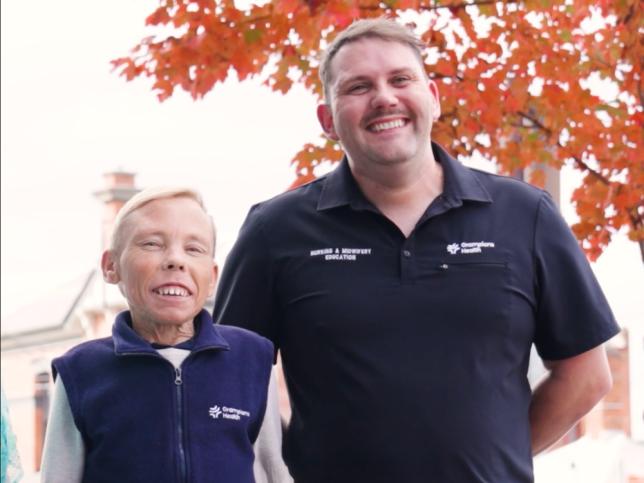 Two men in Ballarat Health uniforms grin at the camera