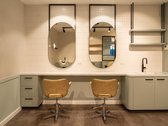 Two seats in front of two mirrors with a wash station to the right.