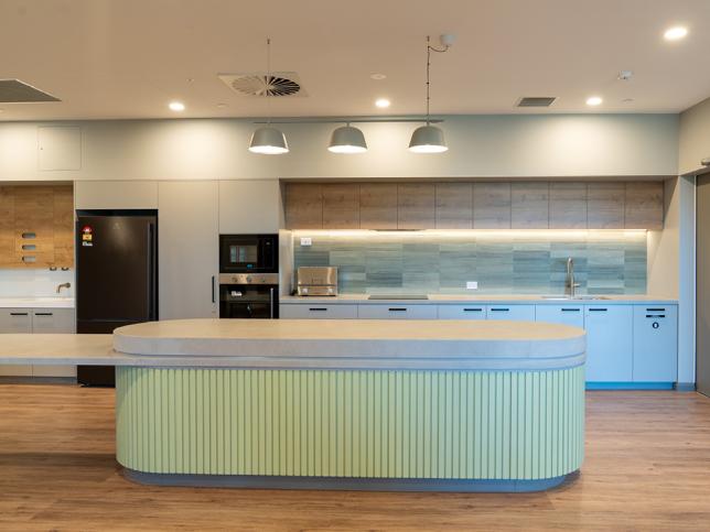 A bright and light kitchen with green and wood tones