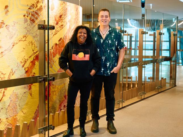 A woman and a man stand smiling proudly