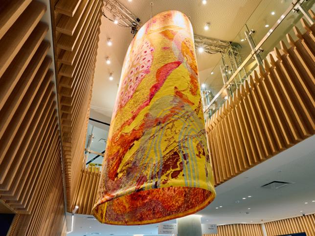 A cylindrical tapestry hanging from a high ceiling