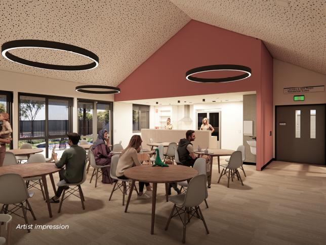 An artist's impression of a modern, spacious room with a vaulted ceiling and contemporary circular light fixtures. Several people are seated or standing around wooden tables. A counter and exit sign are visible in the background.