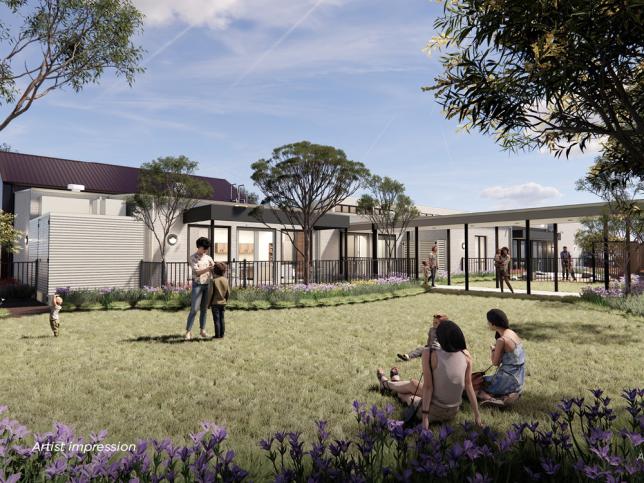 An artist's impression of a grassy open space with a few people enjoying the outdoors. The area is bordered by modern, single-story buildings and shaded by trees. Purple flowers are in the foreground.