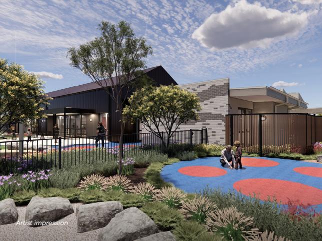 An artist's impression of a modern daycare center building, featuring a mix of dark and light exterior materials and a fenced play area with colorful red and blue circular patterns.