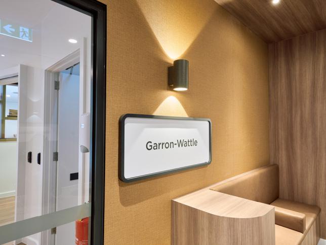 A lit up sign reading the house name