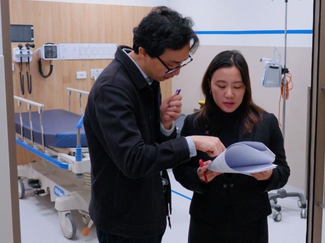 Two clinicians looking at a checklist in a hospital