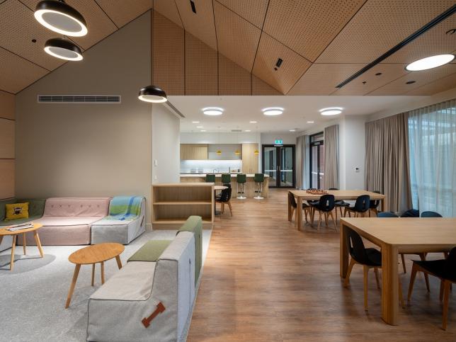A large communal living area with living room and dining tables