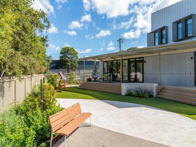 An outdoor space with gardens and a park bench