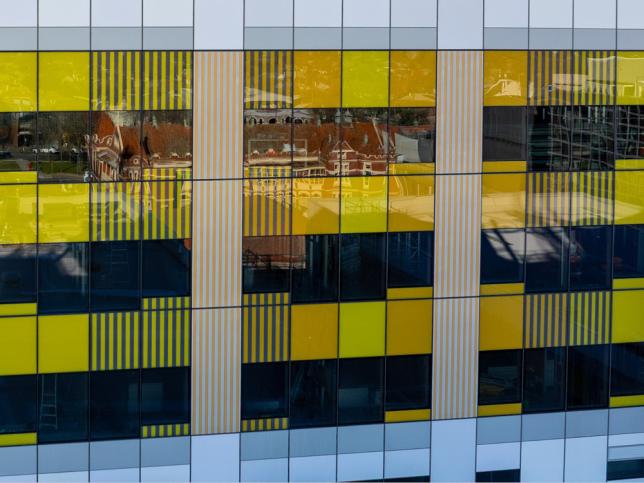 Close-up of the Ballarat Base Hospital redevelopment facade showing yellow, white and dark blue cladding panels and reflective windows.