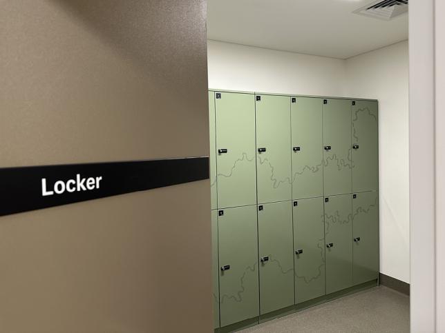Green lockers in a room with a sign reading 'Locker'.