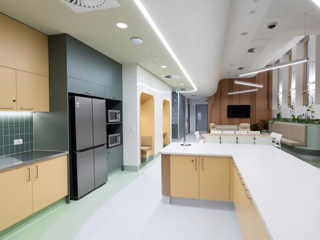 A kitchen with large white bench