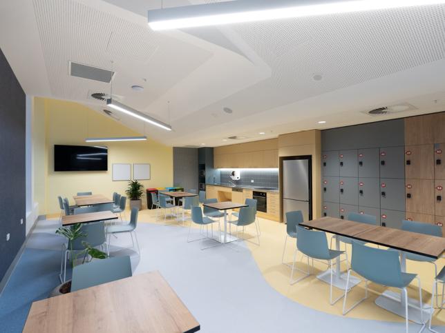 A staff break area with tables and chairs and lockers