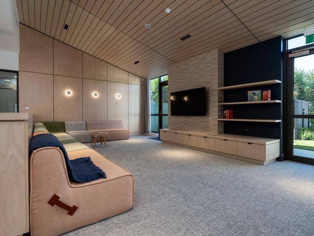 A modern living space with couches, bookshelves and a tv