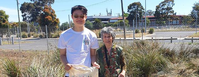 A man and woman standing in front of a grassy area