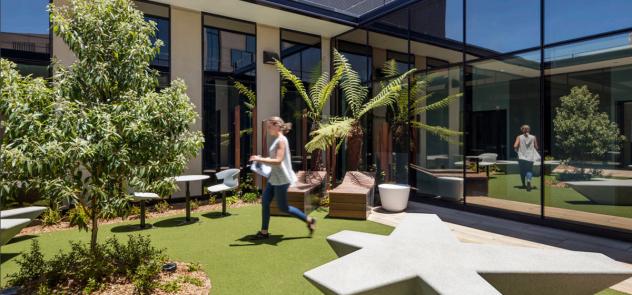 Woman walking across an external garden courtyard at Bendigo Hosptial 