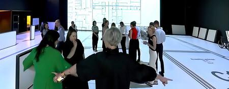 A group of people standing in an open indoor space, looking at plans projected onto the floor