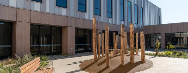 A large newly built facility with wooden artwork out front