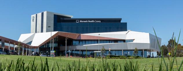 Exterior view of the Monash Health Casey Hospital on a clear day with visible signage and modern architecture.