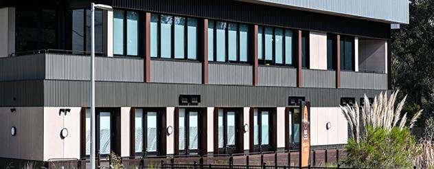 Exterior view of a modern building with a series of large windows and an accessible entrance.