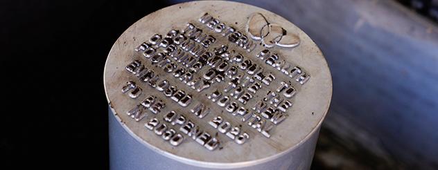Metal cylinder with embossed text