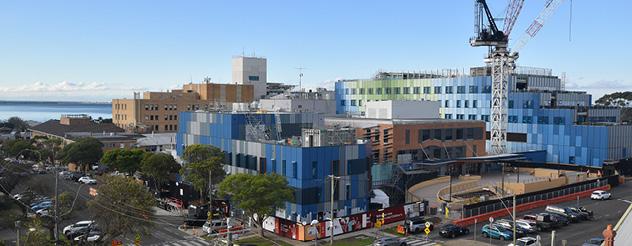 Aerial view of the Barwon Women's and Children's construction site, showing the building under construction with a tower crane and nearby streets.